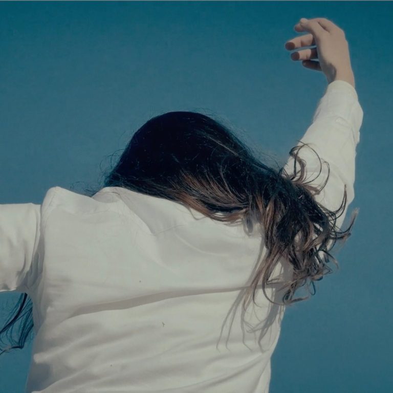 Intérieur minimaliste avec un coussin sur une étagère et des murs dorés.