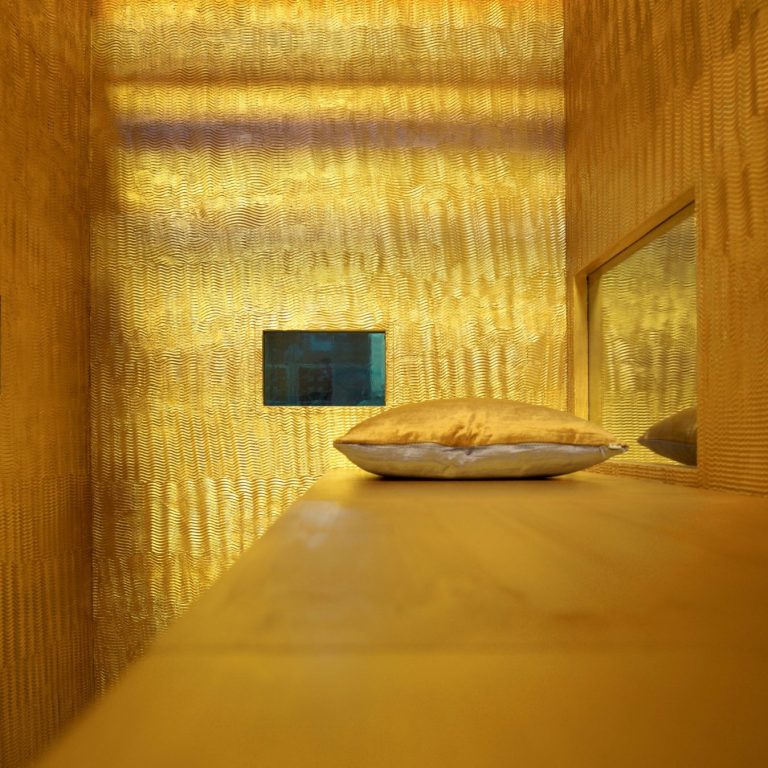 Verre rempli d'eau sur un fond sombre avec des reflets métalliques.